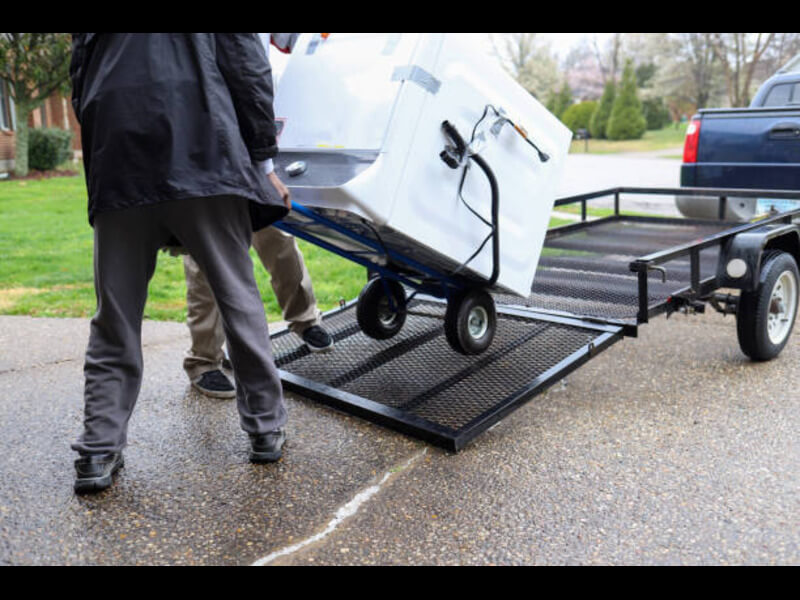 Appliance removal team in San Diego hauling away an old refrigerator