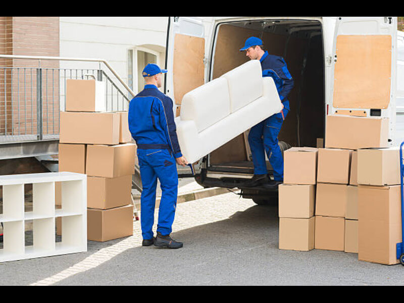 Furniture removal crew carrying an old sofa out of a San Diego home